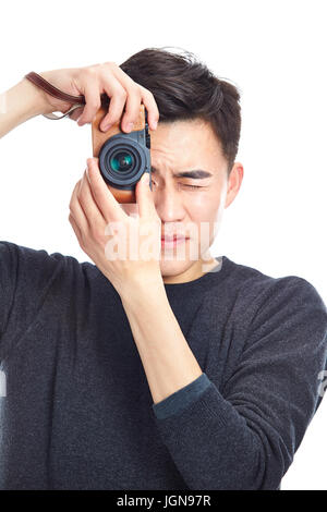 young asian man taking a picture with camera, isolated on white background. Stock Photo