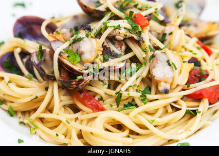 typical italian food - spagetti with vongole clams on plate close up in sicilian restaurant Stock Photo