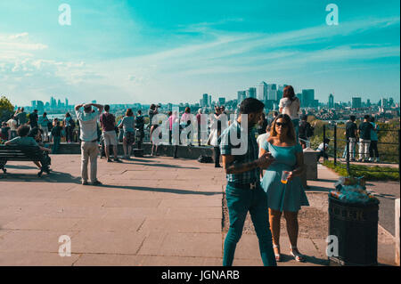 People enjoying the view to Canary wharf from Greenwich park. Stock Photo