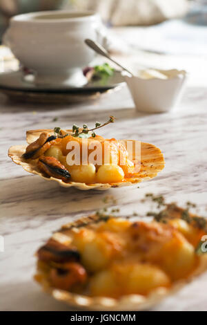 Gnocchi pasta with mussels, tomato and cream room, in vieira shell Stock Photo