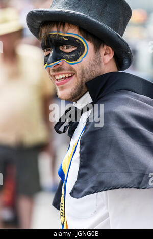 Young man, in Yateley Morris costume, with face painted in form of bandit mask, highwayman, turned to look in viewers direction, no eye-contact, smiling. Stock Photo
