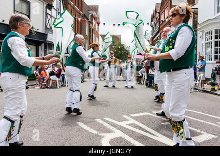 Traditional English folk dancers, Maldon Greenjackets Morris side dancing in the street in the medieval town, Sandwich during folk and ale festival. Swirling white and green hankies around as they perform a dance. Stock Photo