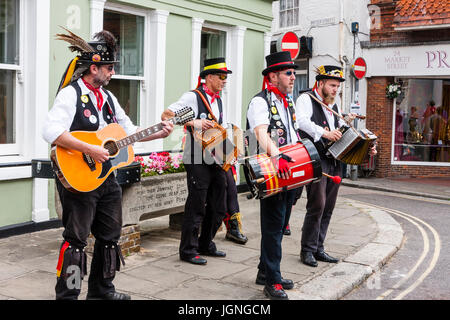 Traditional Folk Music musicians from the Kent Korkers and Pork Scratchin's Morris dancers Side. Four musicians standing on street, playing guitar, accordion and drum. Stock Photo