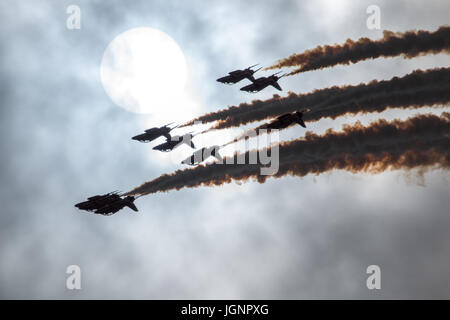 RNAS Yeovilton, Yeovilton, Somerset, UK. 8th July 2017. The RAF Red Arrows reach the zenith of a loop as they are captured in silhouette infront og the Enlish Summer Sun Stock Photo