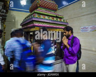 July 9, 2017 - Singapore, Singapore - Hindu guest workers in Singapore walk around a deity in Sri Veeramakaliamman Temple in Singapore's ''Little India.'' There are hundreds of thousands of guest workers from the Indian sub-continent in Singapore. Most work 5 Â½ to six days per week. On Sundays, the normal day off, they come into Singapore's ''Little India'' neighborhood to eat, drink, send money home, go to doctors and dentists and socialize. Most of the workers live in dormitory style housing far from central Singapore and Sunday is the only day they have away from their job sites. Most work Stock Photo