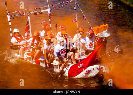Lewes, UK.  9th July 2017. Lewes Bonfire Societies light flares whilst they take part In the annual 'Bonfire Dash' In home made rafts on the River Ouse 'Ouseday' In aid of local charities. The participants are traditionally pelted with eggs by spectators, Lewes, Sussex, UK.  Credit: Grant Rooney/Alamy Live News Stock Photo