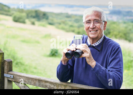 Portrait Of Senior Man On Walk With Binoculars Stock Photo