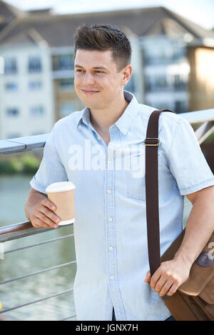 Man With Takeaway Coffee Walking To Work In Urban Setting Stock Photo