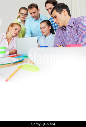 Business team work together looking at one laptop at workplace Stock Photo