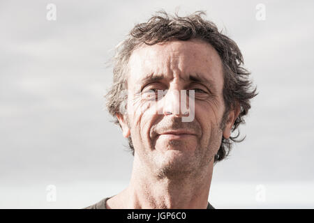 Smiling, unshaven man in his fifties looking at camera Stock Photo