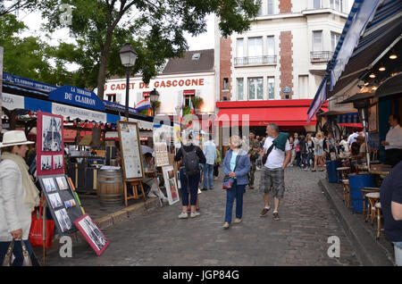 PARIS - AUG 10:  Visitors examine the art in Montmartre in Paris, France on August 10, 2016. The market is near the Basilica of Sacre Coeur. Stock Photo