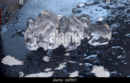 A chunk of melting ice with peeling table on a hot day Stock Photo