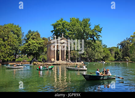 Visitors rowing their boats in the lake of the Villa Borghese gardens, next to the 18th century 'Temple of Asclepius (Aesculapius), Rome, Italy Stock Photo