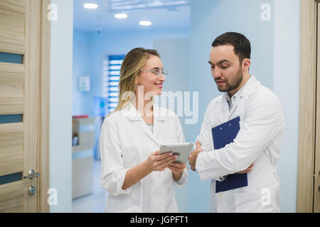 Two doctors discussing diagnosis while walking Stock Photo