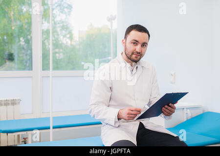 Portrait of handsome young doctor in office Stock Photo
