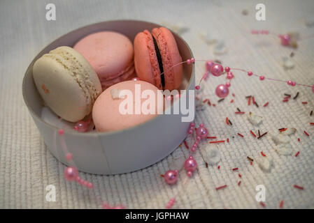 Pastel pink and rose macaroons in a white deep paper bowl Stock Photo