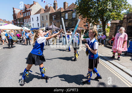 Traditional English folk dancers, Royal Liberty Morris side dancing in the street in the medieval town, Sandwich. Tossing metal poles to each other. Stock Photo