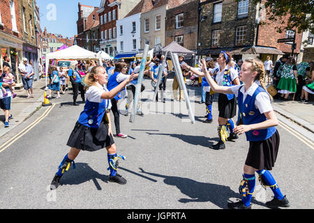 Traditional English folk dancers, Royal Liberty Morris side dancing in the street in the medieval town, Sandwich. Tossing metal poles to each other. Stock Photo