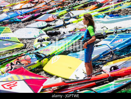 Pozo Izquierdo, Gran Canaria, Canary Islands, Spain. 9th July 2017. High octane windsurfing in nuclear winds as the world`s best wavesailors compete at the first event of the year of the PWA (Professional Windsurfers Association) world tour at Pozo Izquierdo on Gran Canaria ( July 9 - July 15 ). Pozo is famous for its 50 knot + summer winds. PICTURED: A boy competing in the youth event, stands among a sea of boards and sails on Pozo`s rocky beach Stock Photo