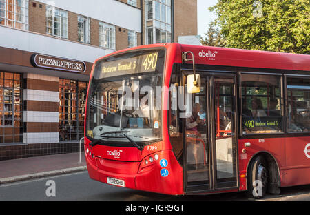 Red single decker London bus No 490 to Heathrow Terminal 5 passing the art deco exterior of the Pizza Express restaurant in Richmond, Greater London. Stock Photo