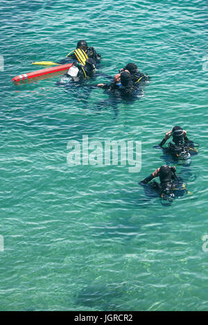 Scuba divers in the sea preparing for a dive. Stock Photo