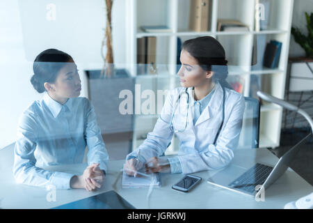 young doctor talking with patient during medical consultation at office Stock Photo