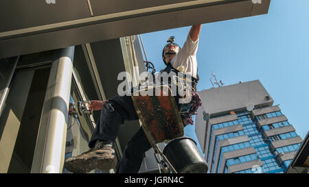 Industrial climbing - Facade Cleaning Service. Workers hanging on climbing ropes.