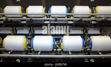 Textile fabric manufacturing machines in work. Stock Photo