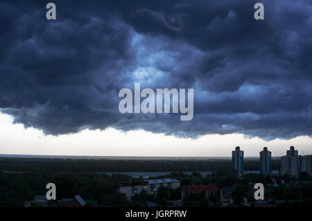 a terrible black cloud is coming to town. dark storm clouds before rain Stock Photo