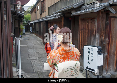 Kyoto, Japan - Two Japanese tourists dressed up as geishas taking photos in gion district Stock Photo