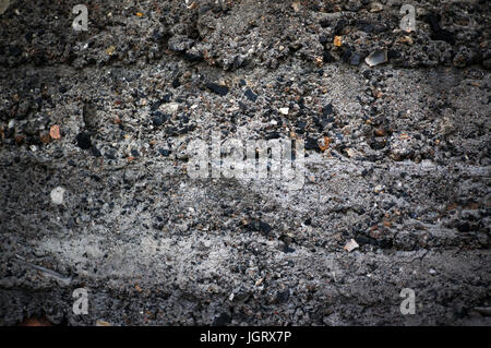 The dark texture of cinder block with coarse rough stones. Exposed aggregate concrete texture background. Concrete wall in grunge style Stock Photo