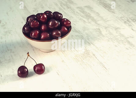 sour cherries dish on white wooden table, directly above Stock Photo