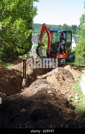 EXCAVATOR in garden digging for mountain heath 2017 Stock Photo
