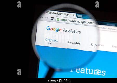 Google Analytics website under a magnifying glass. Google Analytics is a web analytics service offered by Google Stock Photo