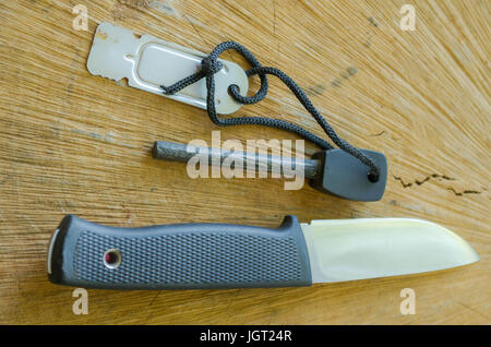 Tourist knife with flint. Knife and flint on wood background. Stock Photo