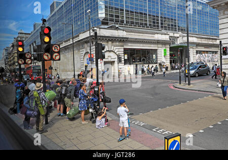 People outside Victoria Coach Station waiting at traffic lights to cross street on Buckingham Palace Road, Victoria, London England, UK   KATHY DEWITT Stock Photo