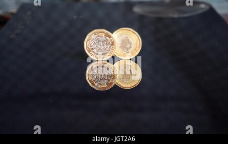 Reflection of two new two pound sterling coins against black backgound (back and front of the coin) Stock Photo