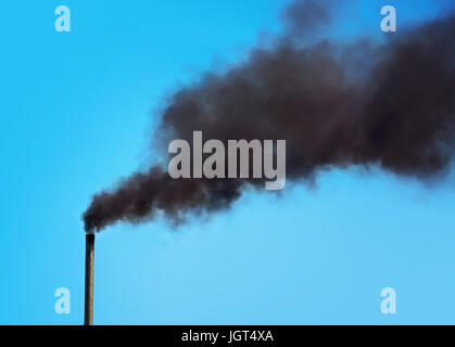 Black pipe with black smoke. Factory chimney smoking, heavy black smoke on the sky. ecology problems Stock Photo