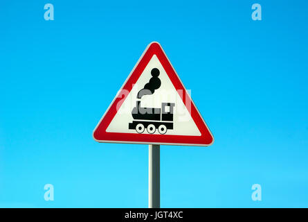 Railroad Level Crossing Sign without barrier or gate ahead the road, beware of train roadside steam engine locomotive signage road sign on signpost po Stock Photo