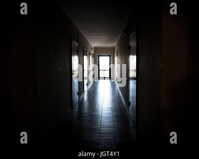 Long dark corridor with doors to the apartments, gave the tunnel the light. an apartment building or Dorm black background. Stock Photo