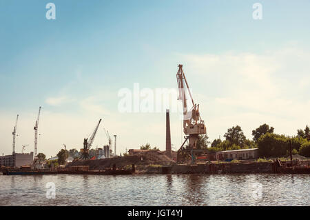 Crane on the river Bank in the port, the construction of the embankment on the river Stock Photo