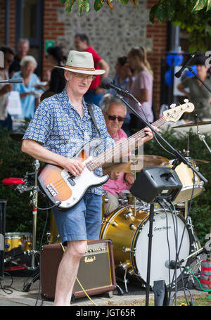 Man in a music band standing outside playing the guitar. Stock Photo