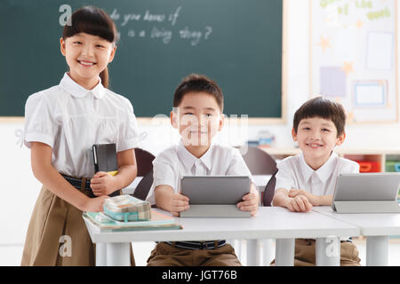 Students using digital tablet in classroom Stock Photo