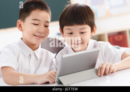 Two students using  digital tablet in classroom Stock Photo