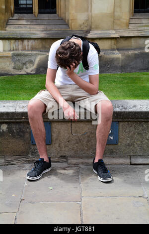 Young man sitting with his head reating on his hand in Cambridge Cambridgeshire England Stock Photo