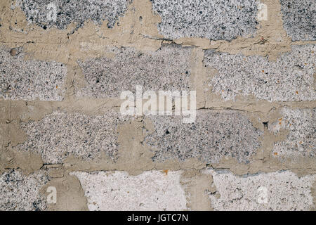 Part of an unplastered brick wall made up of gray blocks. The texture of a gray stone. Stock Photo