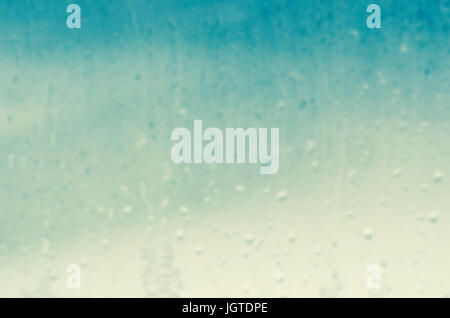 Watery background blur of  raindrops trickling down a glass window pane. Stock Photo