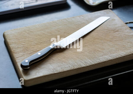 Knife on a wooden cutting board in the kitchen close up Stock Photo