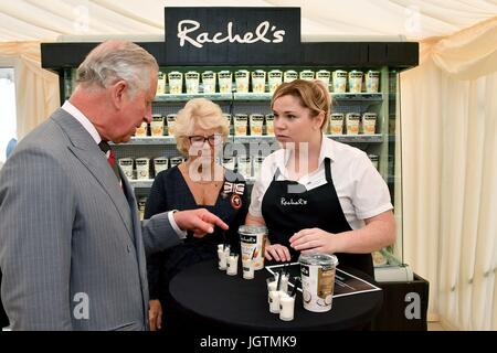The Prince of Wales is joined by Rachel Cooper (centre), founder of Rachel's Organic, as he speaks to employee Rachel Brittain (right) and samples produce during a visit to Rachel's Organic in Aberystwyth, a company which produces organic yoghurt, where he will officially open the firm's new extension, before meeting employees. Stock Photo