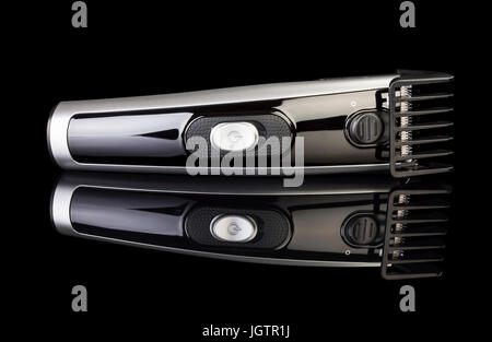 Black hair clipper isolated on black background. Stock Photo